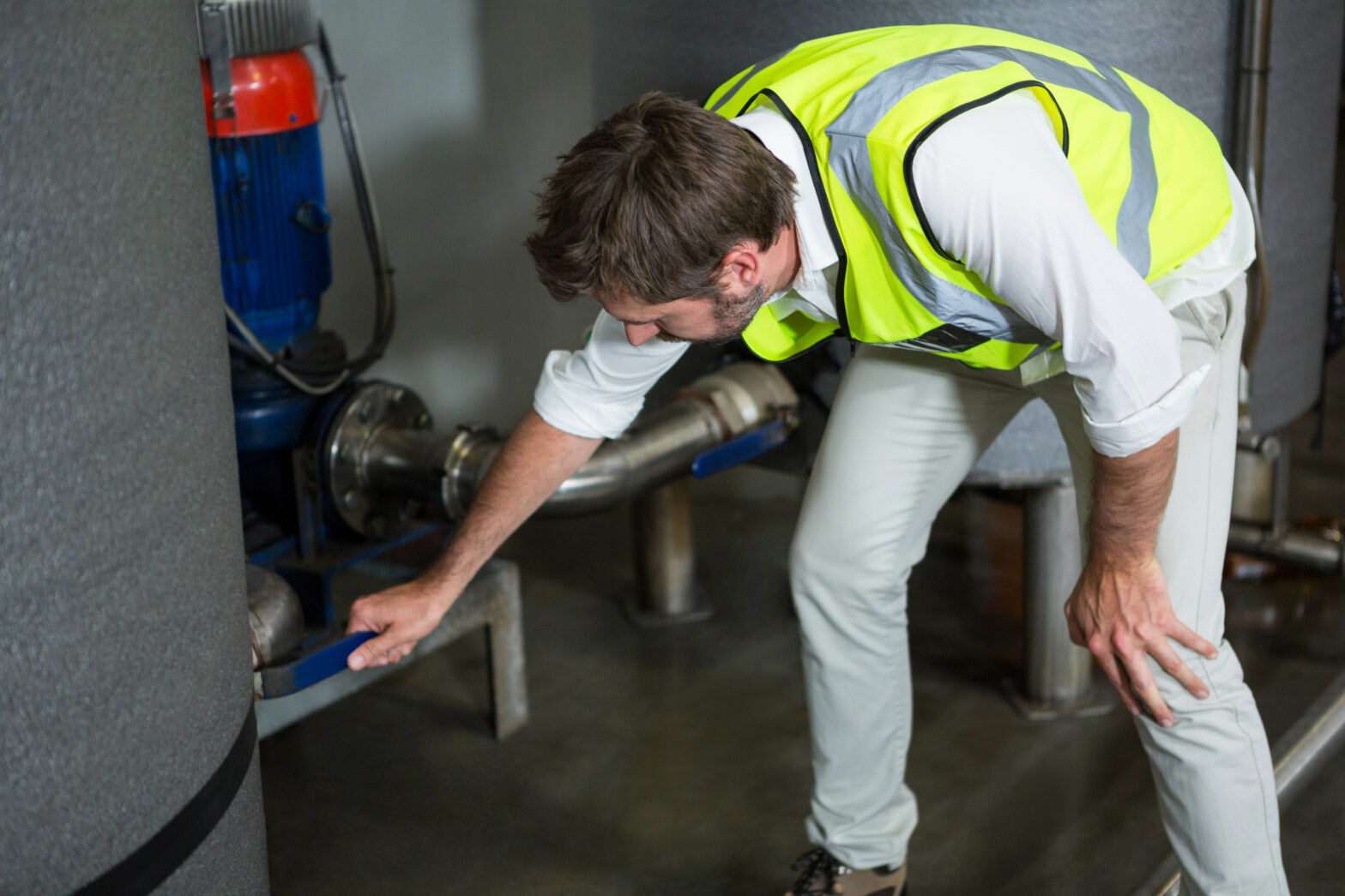 Engineer inspecting high-pressure steam piping to prevent rupture and ensure workplace safety