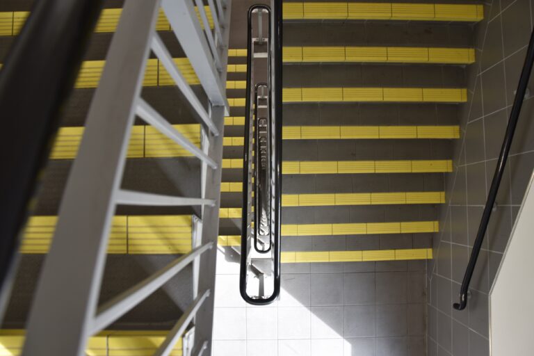 Top view of industrial staircase with yellow anti-slip tread markings for enhanced safety.