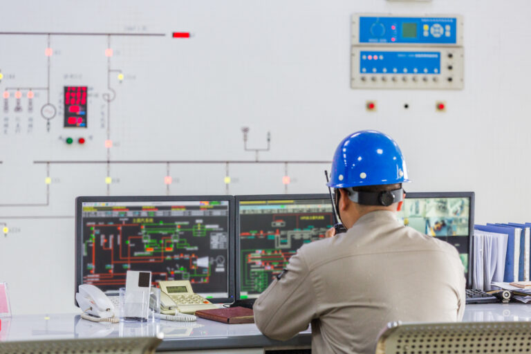 Team of engineers and safety officers reviewing emergency protocols at an industrial site.